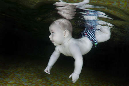 5 months infant learning to swim underwater in waterbaby class in the pool, Eastern Europe, Ukraineの写真素材