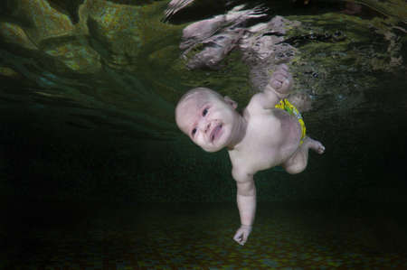 4 months infant learning to swim underwater in waterbaby class in the pool, Eastern Europe, Ukraineの写真素材