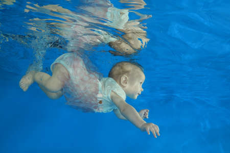 10 months girl to swim underwater in the poolの写真素材