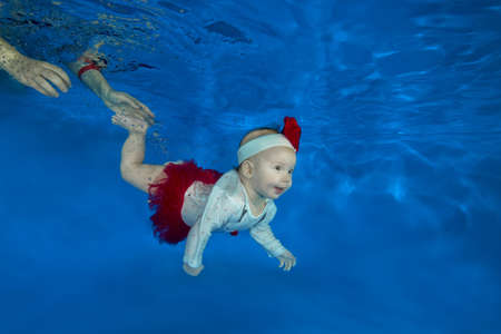 4 months girl to swim underwater in the poolの写真素材