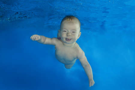 4 months girl to swim underwater in the poolの写真素材