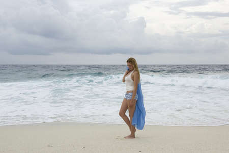 Young woman walks along a deserted beachの写真素材