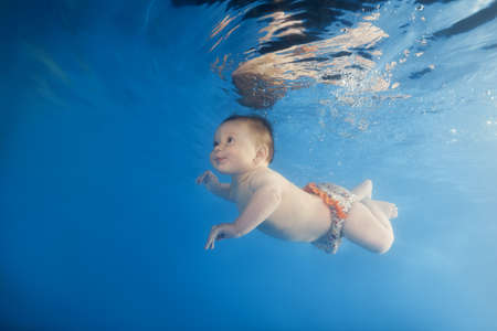 little girl dives underwater in the poolの写真素材