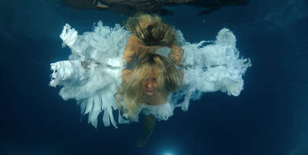 Young beautiful woman in the image of an angel underwater