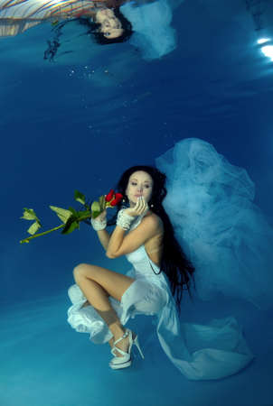 Bride in a wedding  with flowers underwater in the pool. Underwater wedding の写真素材