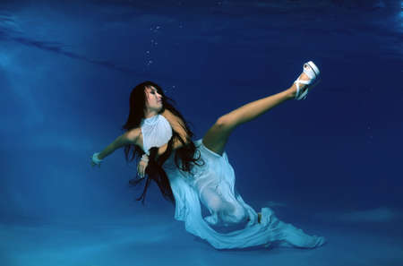 Bride in white dress underwater in the pool. Underwater wedding の写真素材