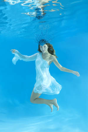 The Snow Queen - The young beautiful woman in a crown and white dress posing under water (for calendar, winter, January)の写真素材