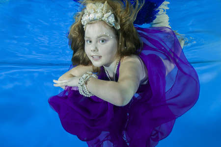 girl in long, lilac dresses wearing poses underwater,の写真素材