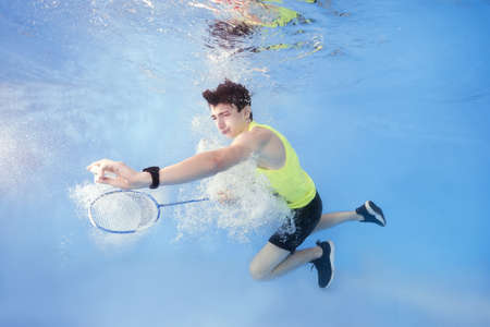 Teen plays badminton underwaterの写真素材