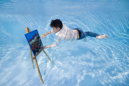 boy draws underwaterの写真素材
