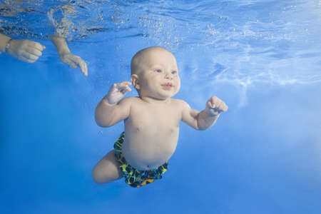 4 months boy dives underwater in the poolの写真素材