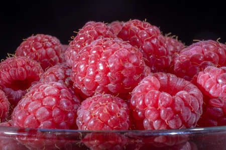 Close-up of European raspberry or red raspberry (Rubus idaeus) on black background.