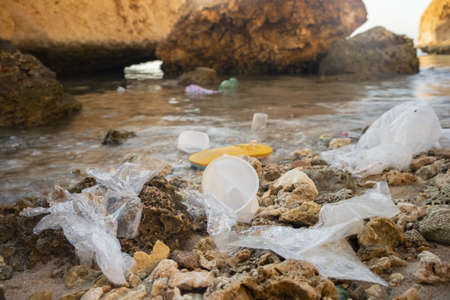 Plastic debris and face masks on the beach. Coronavirus COVID 19 is contributing to pollution, as discarded used masks clutter polluting beaches along with plastic trash. Red Sea, Sharm el Sheikhの写真素材