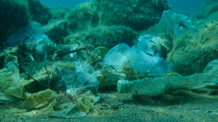 Close-up of the seabed covered with a lot of plastic garbage. Bottles, bags and other plastic debris on seabed in Adriatic Sea. Plastic pollution of the Oceanの写真素材