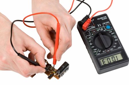 Repair of electronics with digital multimeter in the white backgroundの写真素材