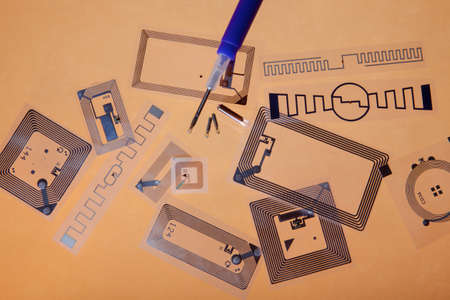 RFID implantation syringe and chips on RFID tags, orange backgroundの写真素材
