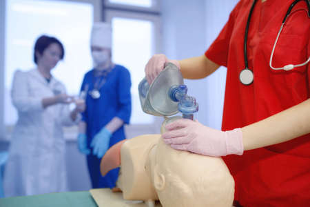group of medical workers. The concept of the practice of artificial breathing by a young doctor. Forced oxygen delivery to the patients lungs by a nurse. CPR backgroundの写真素材