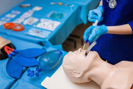 introduction endotracheal tube (ETT) into trachea ensure airway patency. female medical student performs procedure examの写真素材