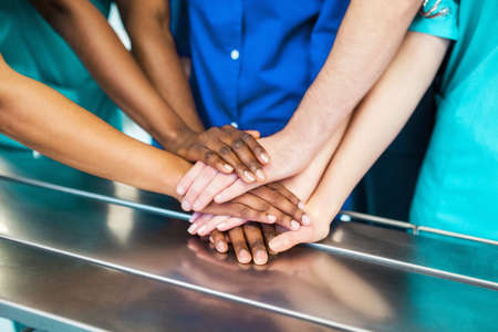 Directly below shot of multiethnic medical team stacking hands over white backgroundの写真素材