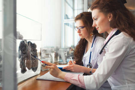 Medical school classroom. A group of Young Nurses girls, studies the internal structure of the Human being on the drug Lungs. The concept of training for professional anatomistsの写真素材