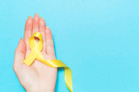 yellow cancer awareness ribbon with trail on white background. concept of health and medicineの写真素材
