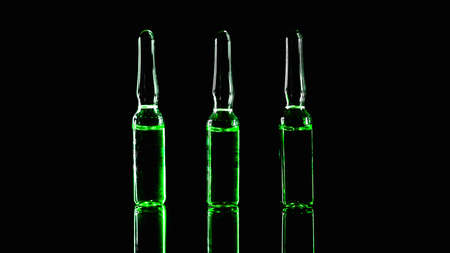 green ampoules on a black background. Narcotic acid. low key photo.の写真素材