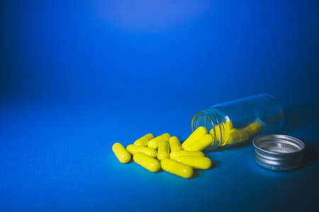White tablets and bottle for tablets on blue background.の写真素材