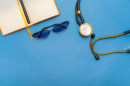 Medical examination and healthcare business graph. Glasses, diary and stethoscope on a blue...