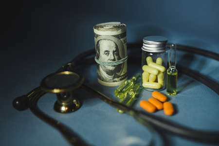 Medicine pills or capsules with money, dollar. Medical or pharmacy prescription for health. Business, finance concept. Cost of the healthy life. Bottle of drugの写真素材