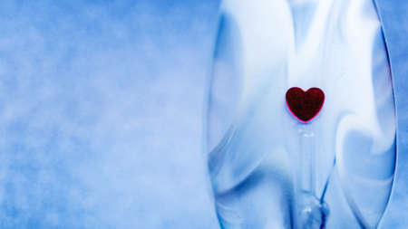 Plain blue background with little red heartの写真素材