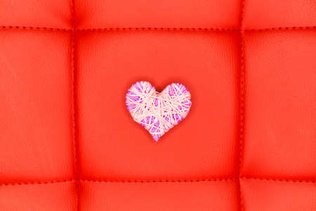 White heart made of wool on a red background. Valentines Day.の写真素材