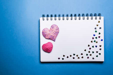 Simple blue background with a small purple red heart yn notebook. Place for textの写真素材