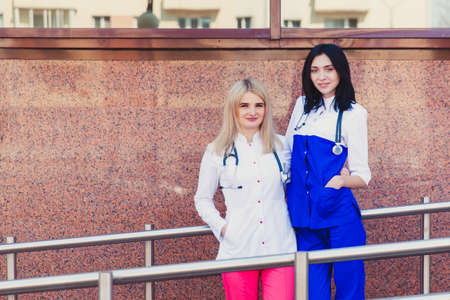 Two young girls intern doctor on the background of the hospital. The concept of health and medical...