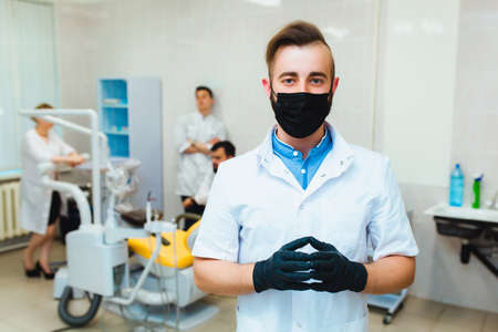 Dental clinic. Portrait of a professional dentist on the background of a working team of doctors. Concept of medical education and medical insurance.の写真素材