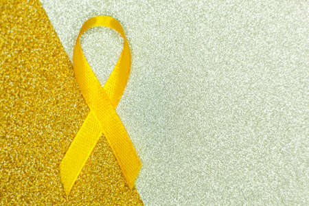 Gold ribbon for children as a symbol of childhood cancer awareness. World Cancer Day.