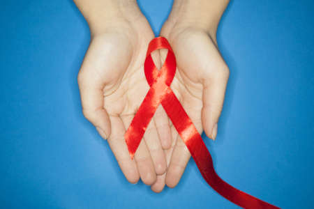 Red AIDS awareness ribbon on blue