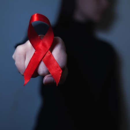 Red AIDS awareness ribbon on black
