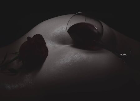 Adorned in a rose and glass of wineの写真素材