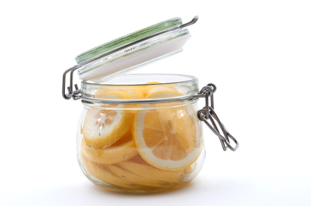 Lemon slices in a glass jar are covered with sugar, top view.の写真素材
