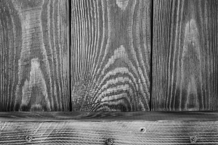 Black and white Textural background of wooden boards arranged vertically and one horizontal board.の写真素材