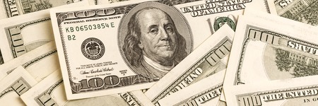 A background of one hundred dollar bills in a vintage style with a focus on one of the bills.