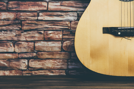 Acoustic guitar on a brick wall background.の写真素材