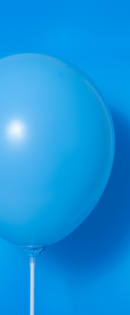 Blue balloon on blue background with shadow. Side glareの写真素材