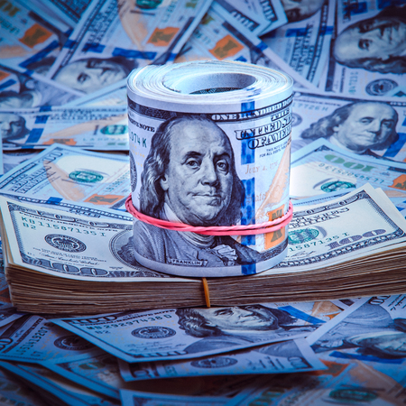 A pile of one hundred US banknotes. Cash of hundred dollar bills, dollar background image.の写真素材