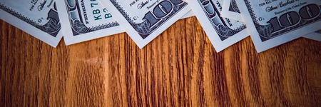 Dollar banknotes are lying at wooden background