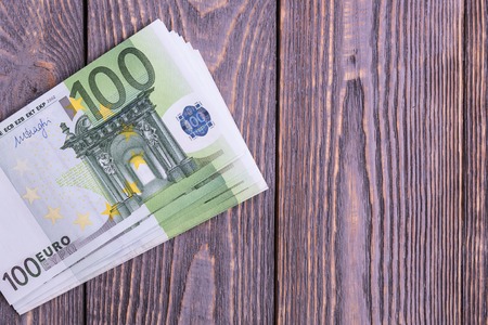 Euro cash banknotes on a dark wooden backgroundの写真素材