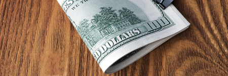 Dollar banknotes are lying at wooden background