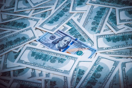 Background from dollars. Notes of one hundred American dollars are scattered across the background