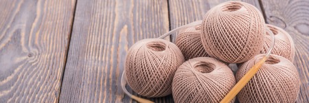 Balls of yarn and knitting needles for knitting on a wooden background