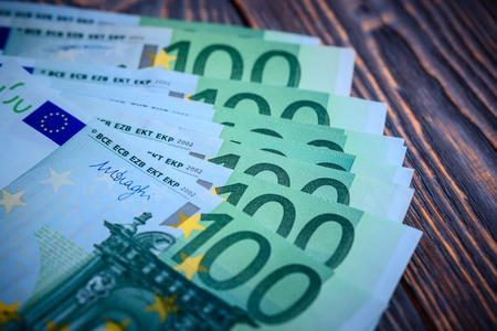 Euro cash banknotes on a dark wooden backgroundの写真素材